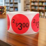 2 for 3 dollars label on a red round sticker with black print
