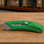 Green S4TM right-handed safety box cutter for warehouse use.