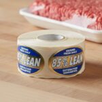 85% Lean Ground Meat labels on a foil sticker with white and blue print on a butcher counter