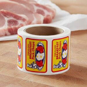 Breakfast Pork Chops Sticker on a roll of white rectangle labels with Yellow, Red and Blue Print showing a small man on a plate of pork chops