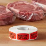 ribeye steak sticker on a red label with black text